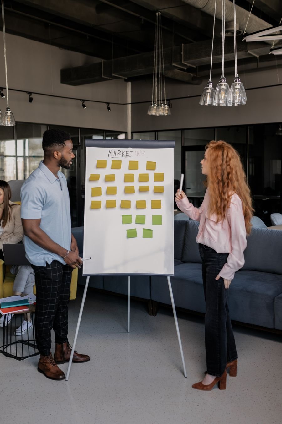 Colleagues reviewing a campaign plan on sticky notes